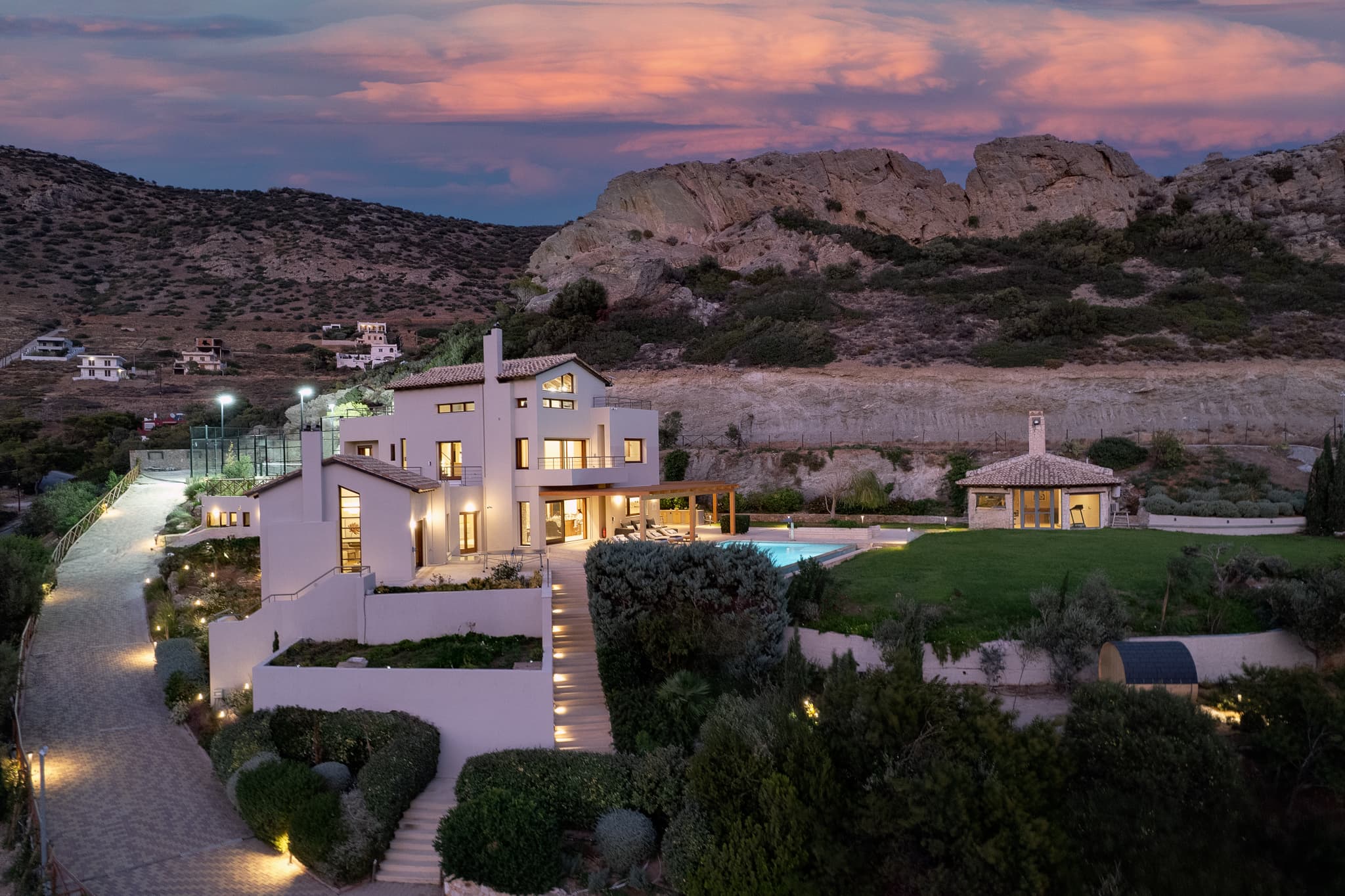 Villa Lithos Porto Rafti at sunset, aerial view of the estate with pool and sea beyond